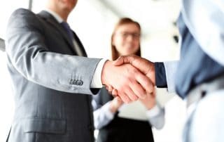 two private equity investors shake hands becuase they increased portfolio value