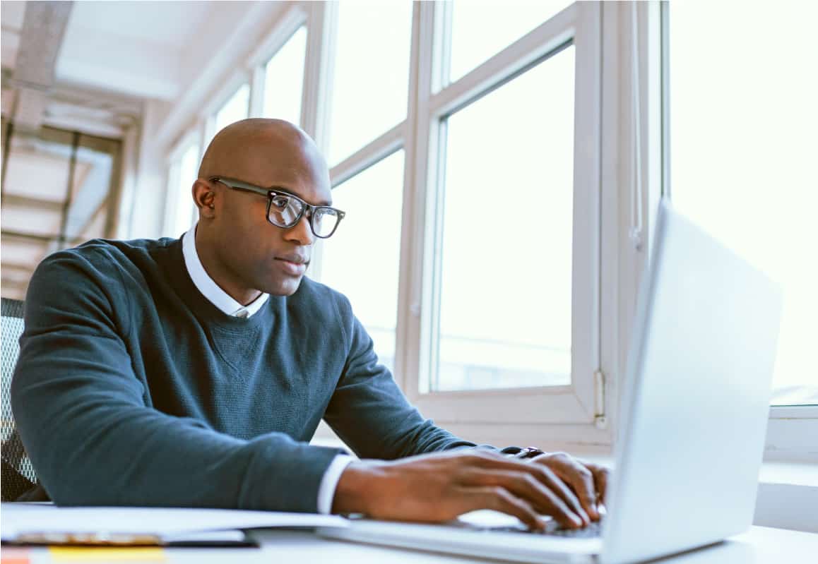 a man typing on a laptop using subscription pricing